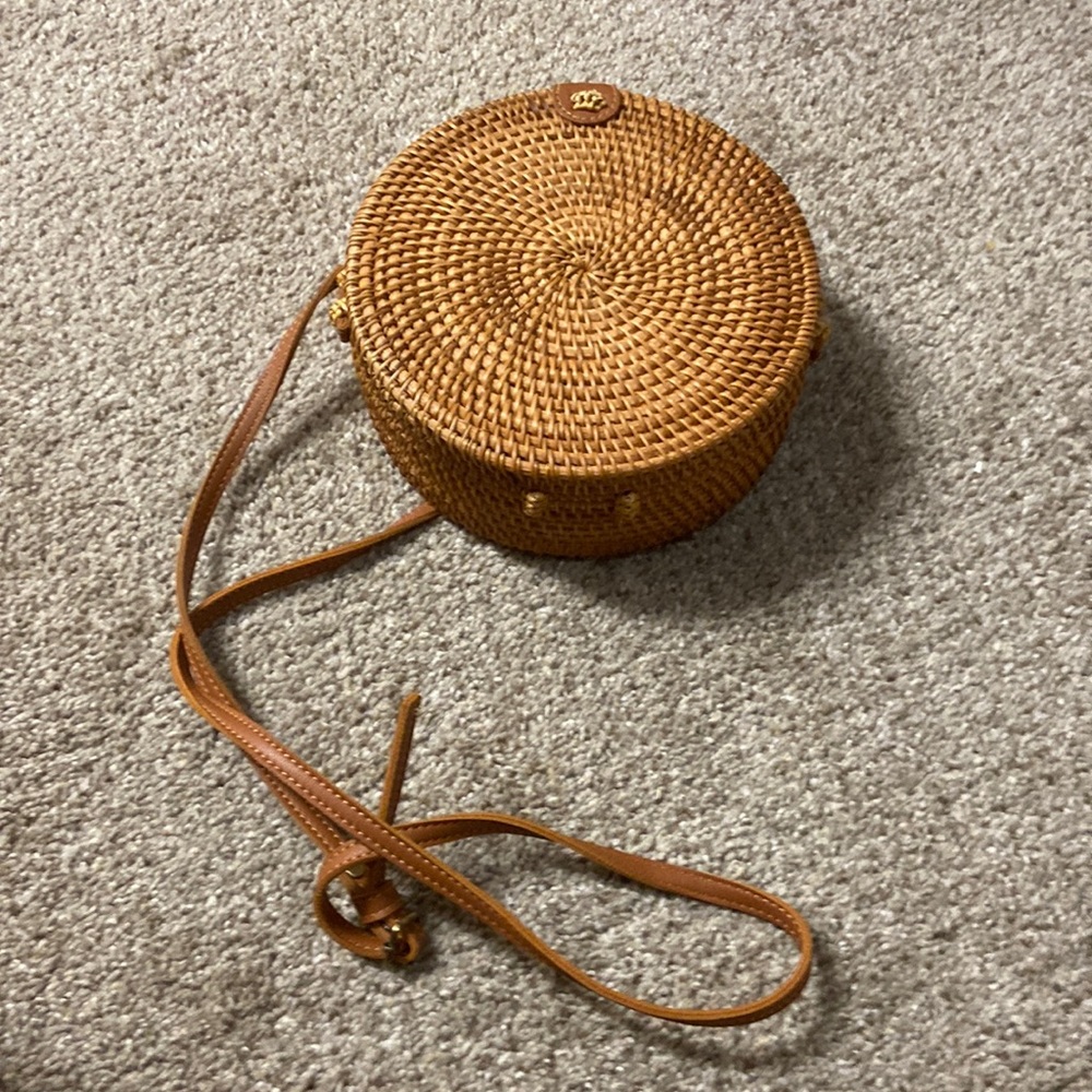 Round, wicker purse with floral interior.